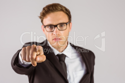 Young serious businessman pointing at camera