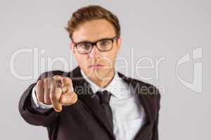 Young serious businessman pointing at camera