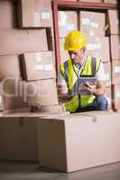 Warehouse worker using digital tablet in warehouse