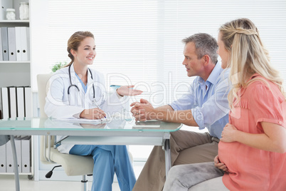 Happy couple talking to doctor