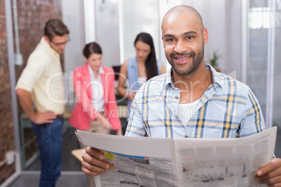 Smiling man reading the newspaper