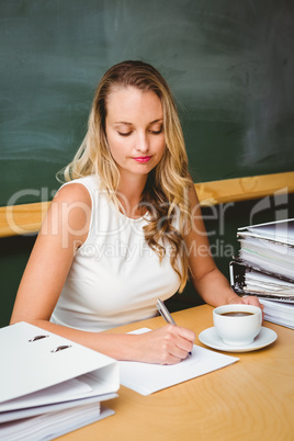 Beautiful businesswoman writing document at desk