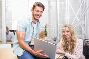 Business people smiling and working together with a laptop