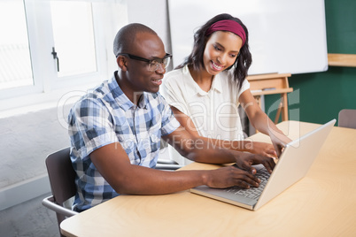 Partners working at desk using laptop