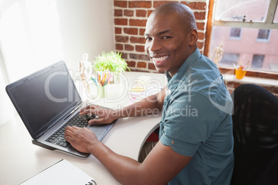 Casual businessman working on laptop at desk