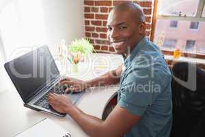 Casual businessman working on laptop at desk