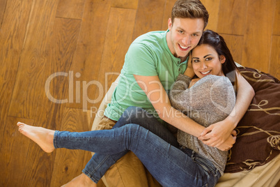 Cute couple cuddling on beanbag