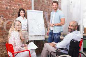 Casual business team having a meeting smiling at camera