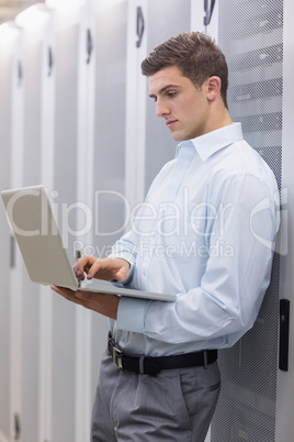 Focused technician typing on his notebook