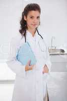 Smiling brunette standing and holding folder