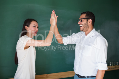 Happy business people high fiving in office