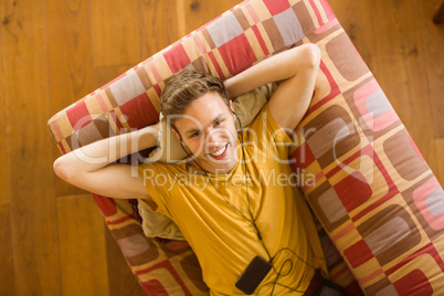 Young man listening to music on his couch