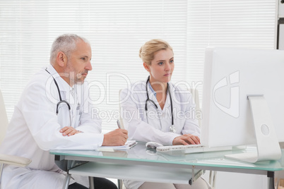 Concentrated doctors coworker using laptop