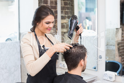 Hair stylist drying mans hair