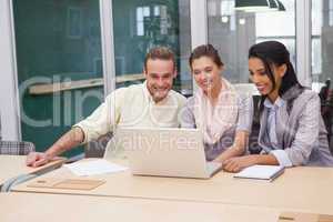 Three happy businessmen working together on a laptop