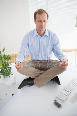 Zen businessman meditating on his desk