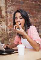 Woman eating a muffin and having a coffee