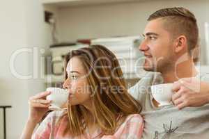 Cute couple relaxing on couch with coffee