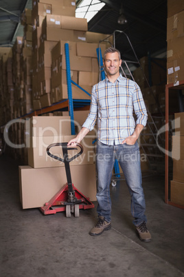Worker with trolley of boxes in warehouse