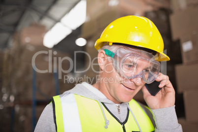 Worker using mobile phone in warehouse