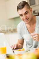 Man using his laptop at breakfast