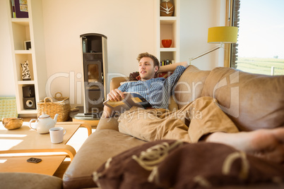 Young man reading on his couch