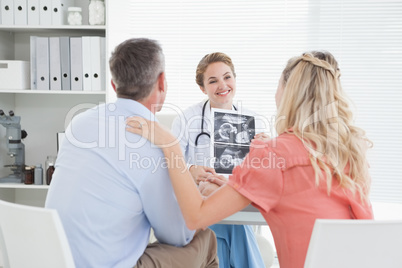 Happy couple talking to doctor