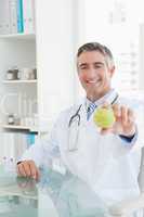 Happy doctor sitting at his desk