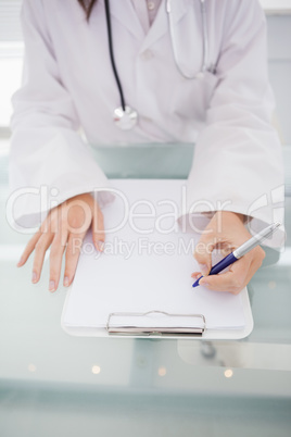 Doctor writing on a clipboard