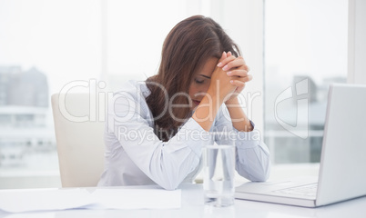 Tired businesswoman sitting at her desk