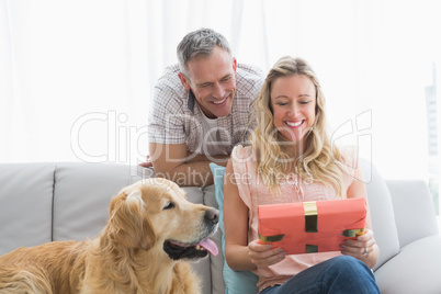 Happy young woman holding her birthday gift in front of her