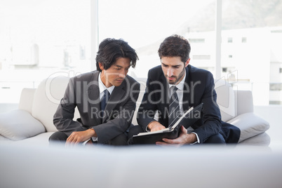 Businessmen sitting on couch together
