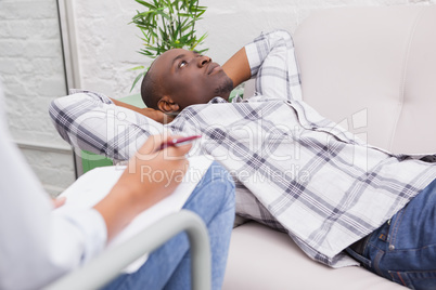 Man lying on sofa talking to his therapist