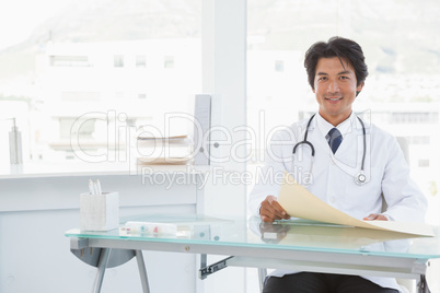 Smiling doctor sitting at his desk