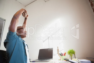 Casual businessman stretching in chair