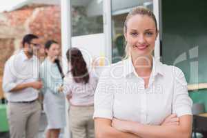 Blonde smiling businesswoman standing with arms crossed