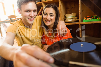 Young couple putting on a vinyl record