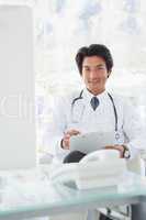 Smiling doctor reading over notes