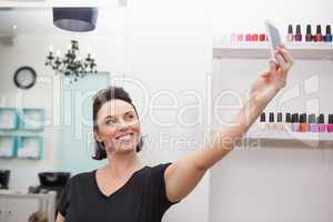 Hairdresser smiling and holding phone