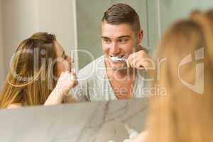 Cute couple brushing their teeth