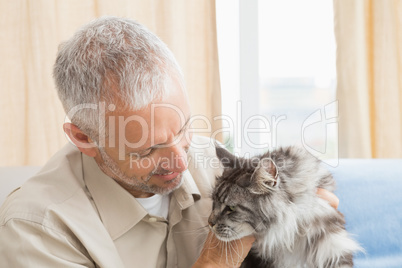 Happy man with his pet cat on sofa