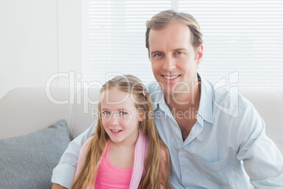 Casual father and daughter smiling at camera