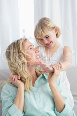 Portrait of a mother and daughter behind her on the couch