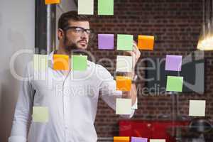 Casual businessman writing on sticky notes
