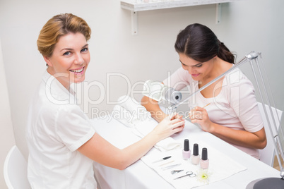 Nail technician giving customer a manicure