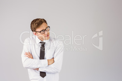 Young businessman thinking with arms crossed