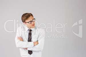 Young businessman thinking with arms crossed