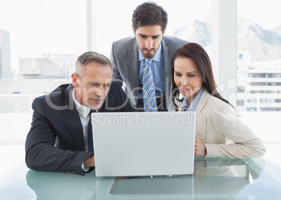 Co workers all looking at a laptop