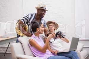 Smiling girls being shown pictures on camera by man