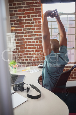 Casual businessman stretching in chair